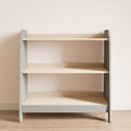 A gray piece of furniture with three shelves for storing children's toys and items. 
