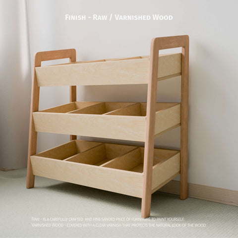 The image shows an empty Montessori-style toy organizer with a choice of raw or varnished wood finish. It features three tiers of open bins made from natural wood, ideal for organizing children's toys. The raw wood option is finely sanded, ready for painting or personal finishing, while the varnished wood is coated with a clear varnish to protect and highlight the natural wood grain. 