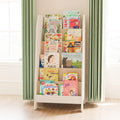 White, tall and narrow six-shelf children's bookshelf in which the books are arranged with the cover to the front.
