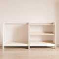 Set of Montessori closet and storage for toys in playroom in white with wooden shelves.