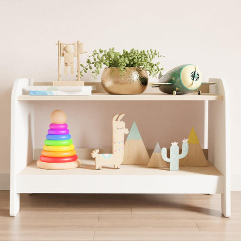 White low toy storage, with two shelves. On the shelves children's toys.