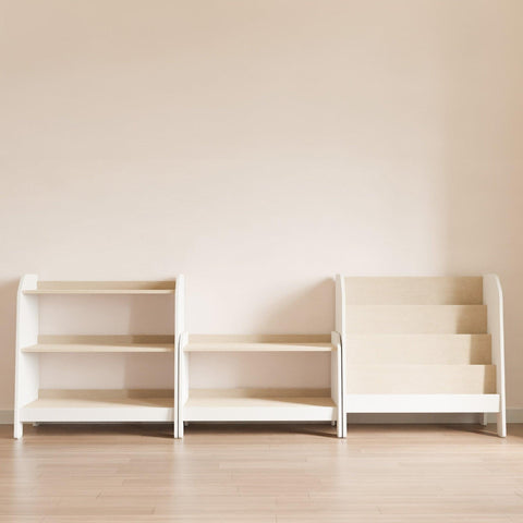 A set of three Montessori furniture: a medium toy bookcase, a low toy bookcase for storage, and a bookshelf for books, arranged facing the child in white with wooden shelves.