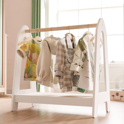 White montessori clothing rack for storing clothes and accessories.