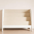 A white nursery bookcase with four wooden shelves for stacking books with the cover facing forward.