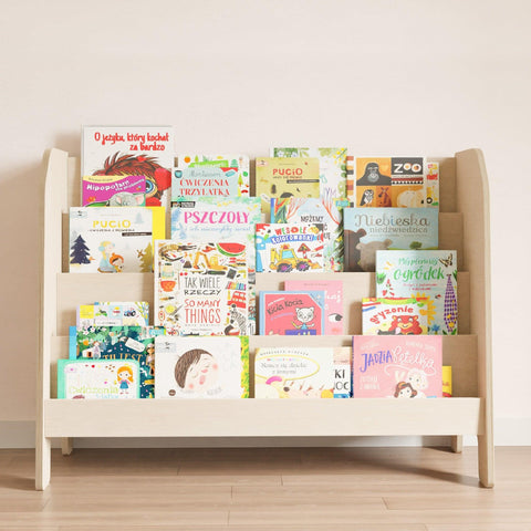 Wide wooden montessori bookcase with four shelves. On the shelves stand children's books placed with the cover to the front.