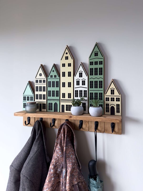 City-inspired wall coat hook and shelf organizer in Green theme featuring mint and beige house silhouettes with dark oak finish