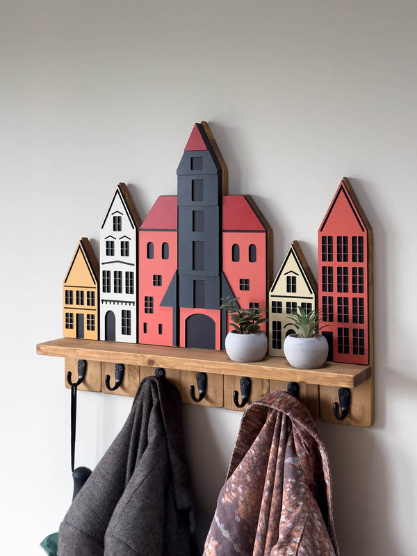City-inspired wall coat rack with shelf featuring colorful Gdańsk old town house facades in dark oak finish holding coats and plants