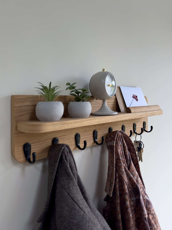 Angled view of mid-century wooden wall organizer shelf featuring mail holder slot and eight hooks with keys and scarf