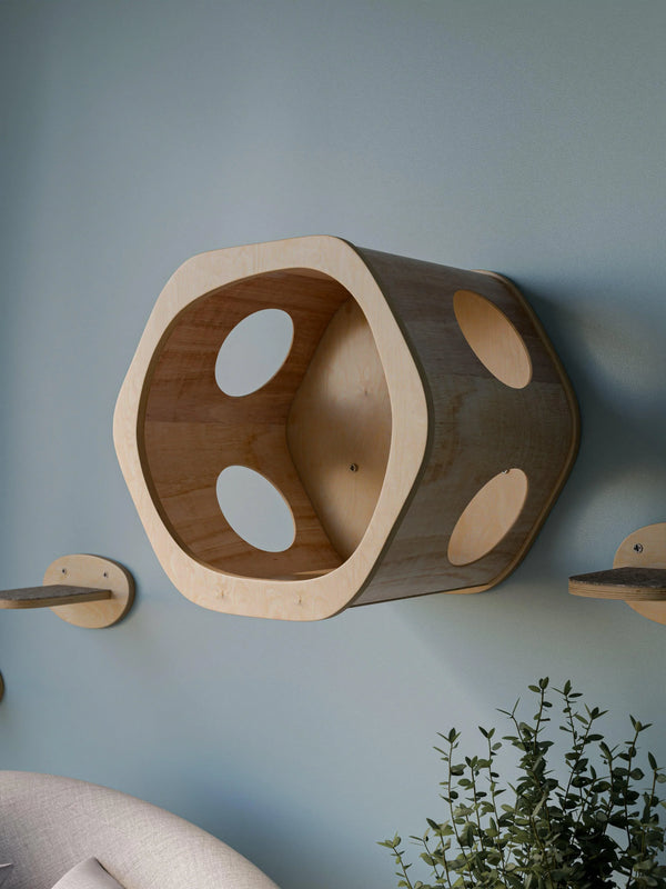 Wall-mounted hexagon cat cave in natural birch plywood with large front opening and side holes installed on wall