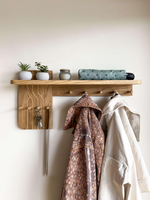 Front view of the Wall-Mounted Oak Coat Rack. This wooden entryway organizer features 9 hooks for hanging coats and keys, topped with a sturdy shelf for daily essentials.